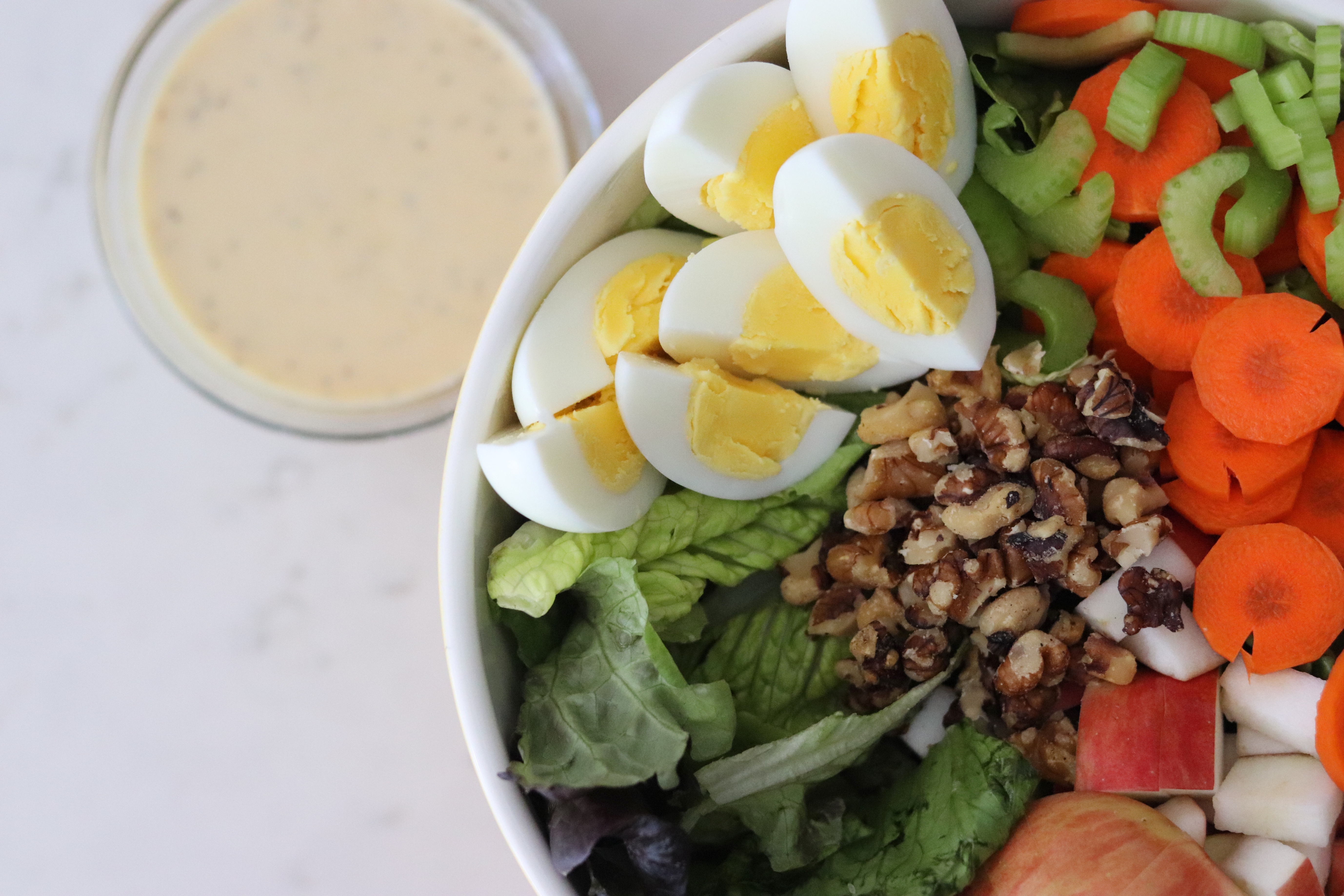 Bowl of Fall Salad with Boiled Egg and a bowl of Honey Mustard Dressing