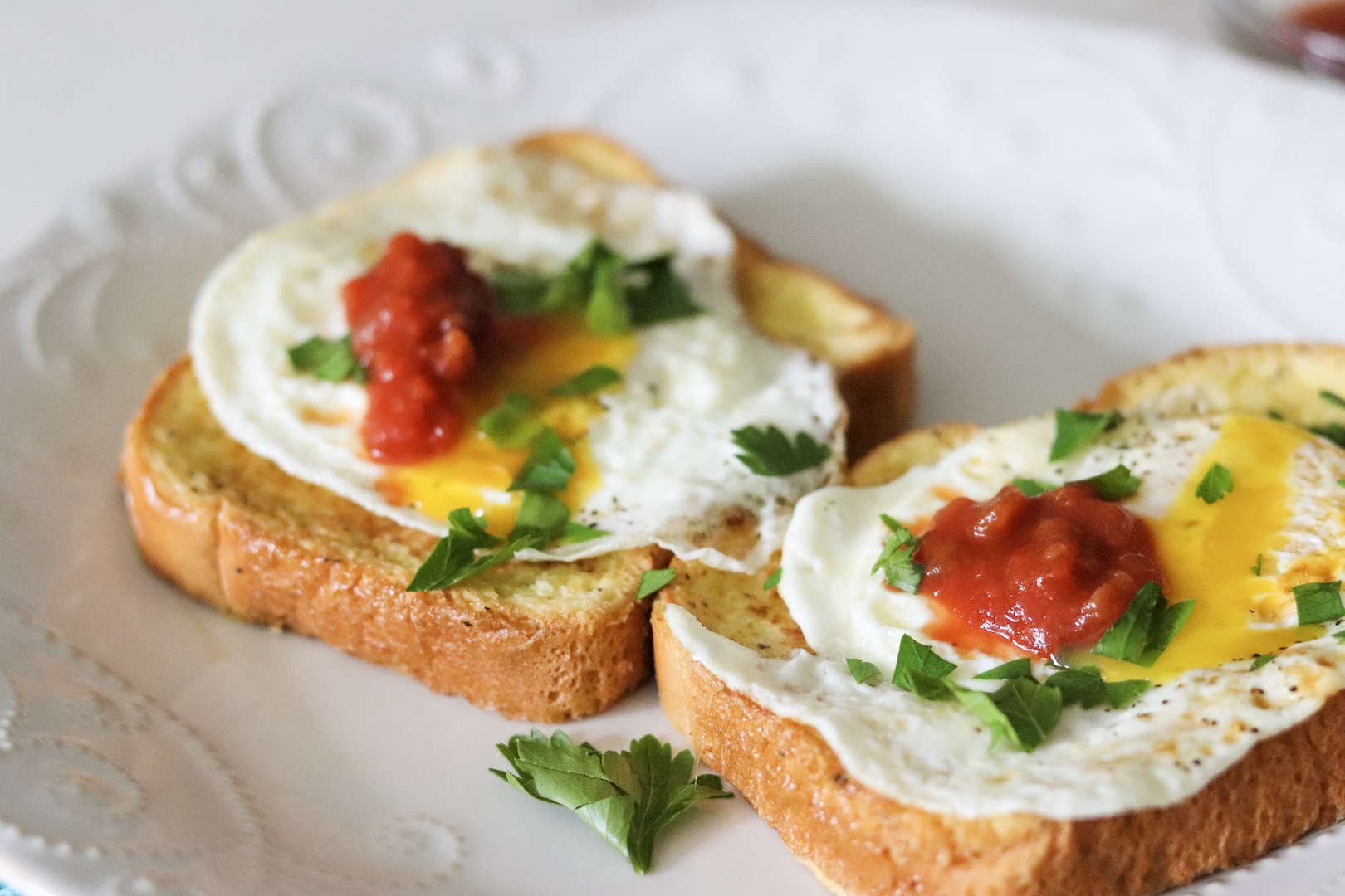 Savory French Toast topped with a fried egg, salsa, and chopped fresh parsley