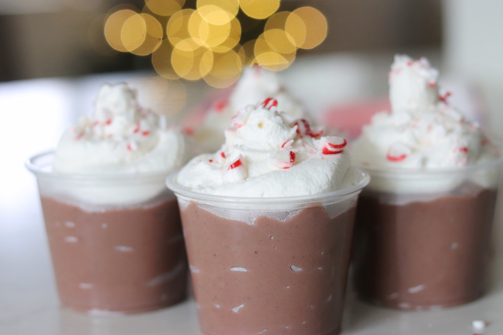 Peppermint Hot Chocolate Pudding Cups with Christmas lights in the background