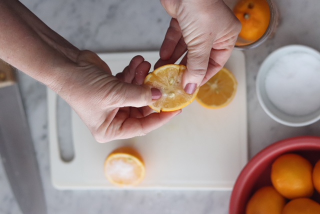 Person rubbing salt into a lemon half