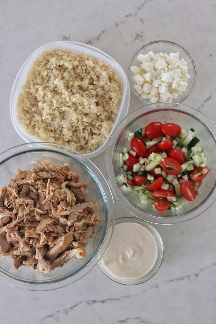 Bowl of Instant Pot Greek Chicken, Tomato and Cucumber Salad, cooked quinoa, and Tahini-Lemon Sauce
