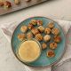 Blue plate with Crispy Oven Fried Tofu Nuggets and a honey mustard dipping sauce